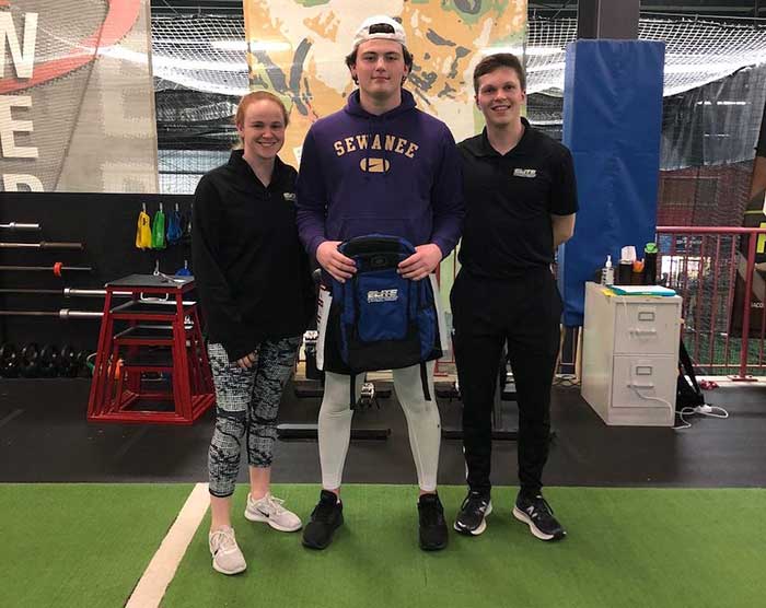 zach standing with his trainers and smiling