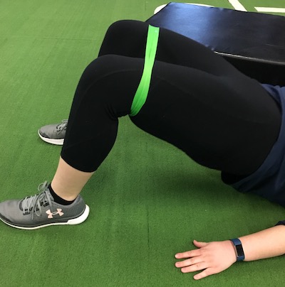 woman lifting hip using stretch band