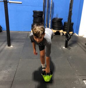 boy picking kettle bell